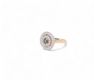 bague en or rose avec des diamants serti en cercle et au centre un saphir vert