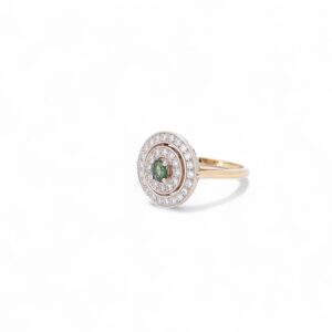 bague en or rose avec des diamants serti en cercle et au centre un saphir vert