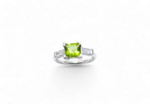 bague or peridot de forme carré au centre et deux diamants baguettes monture en or blanc paladié