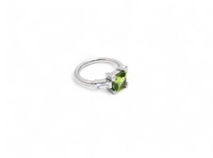 bague en or blanc palladié avec deux diamants baguettes en serti semi clos et un peridot en serti griffe de taille carré